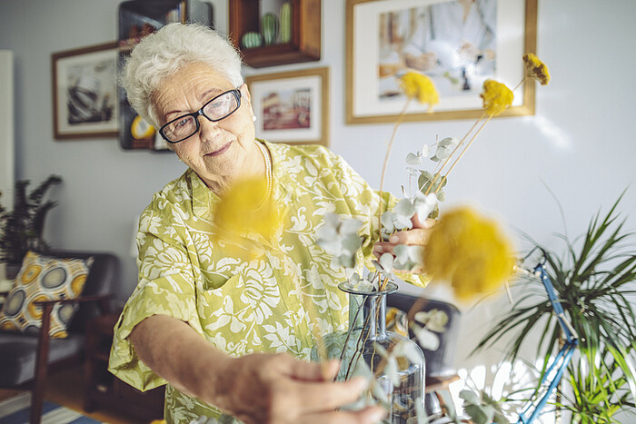 Une femme arrange un bouquet de fleurs jaunes