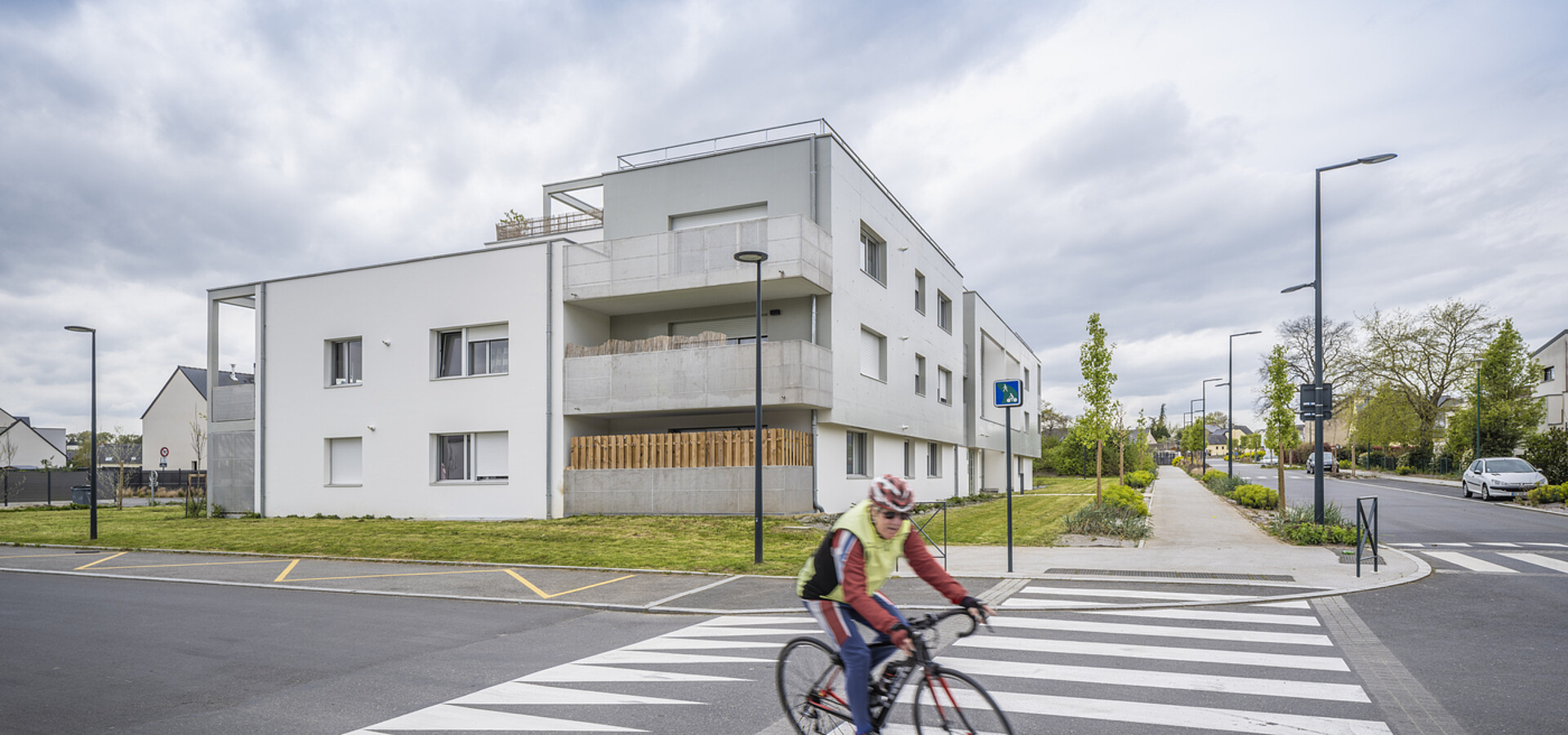 Une personne en vélo face à la résidence "Elsa Triolet" à Orgères