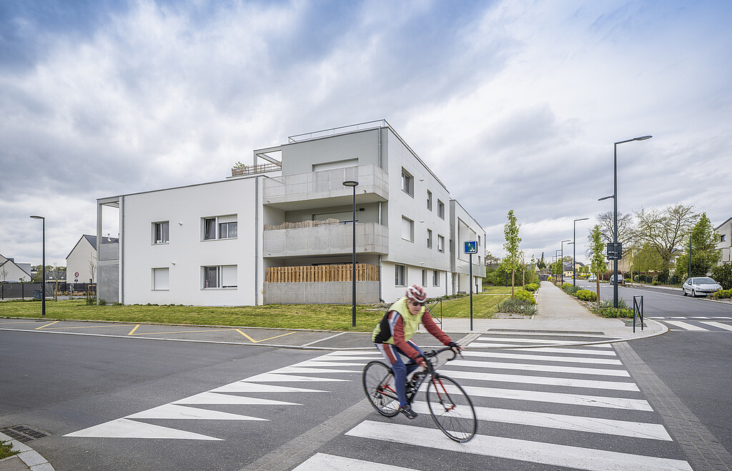 Une personne en vélo face à la résidence "Elsa Triolet" à Orgères