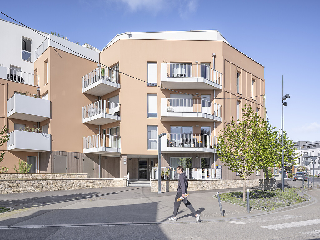 Une personne marche devant la résidence locative Terra Siena à Noyal-sur-Vilaine