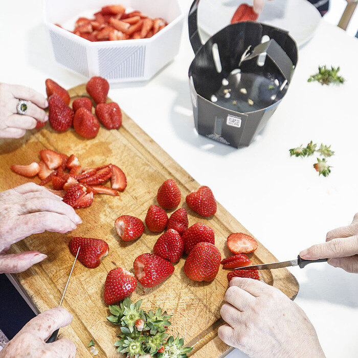 Résidents seniors participant à un atelier cuisine à la Maison Helena de Maen-Roch