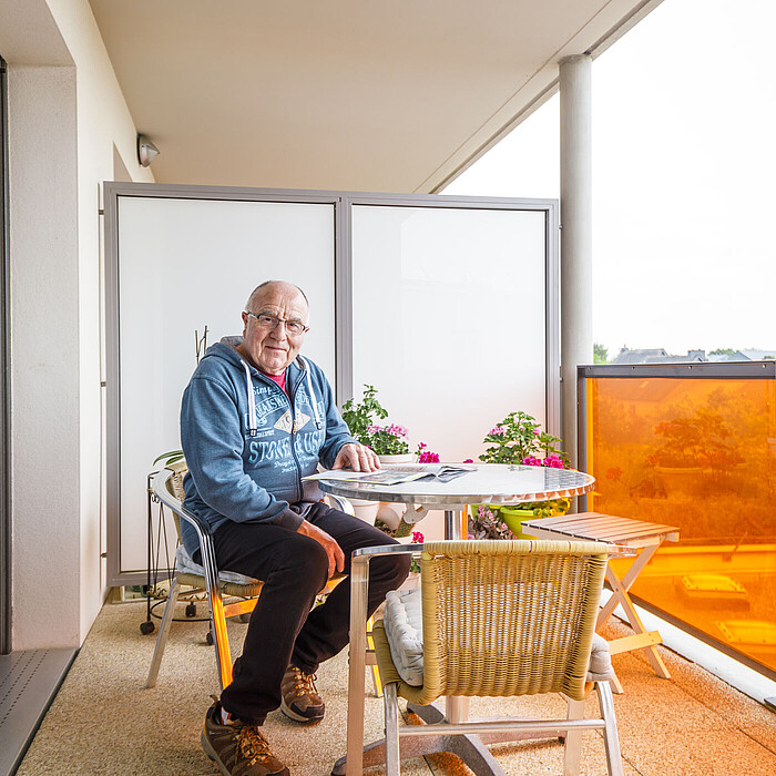 Résident senior profitant de sa terrasse à la Maison Helena de Montgermont