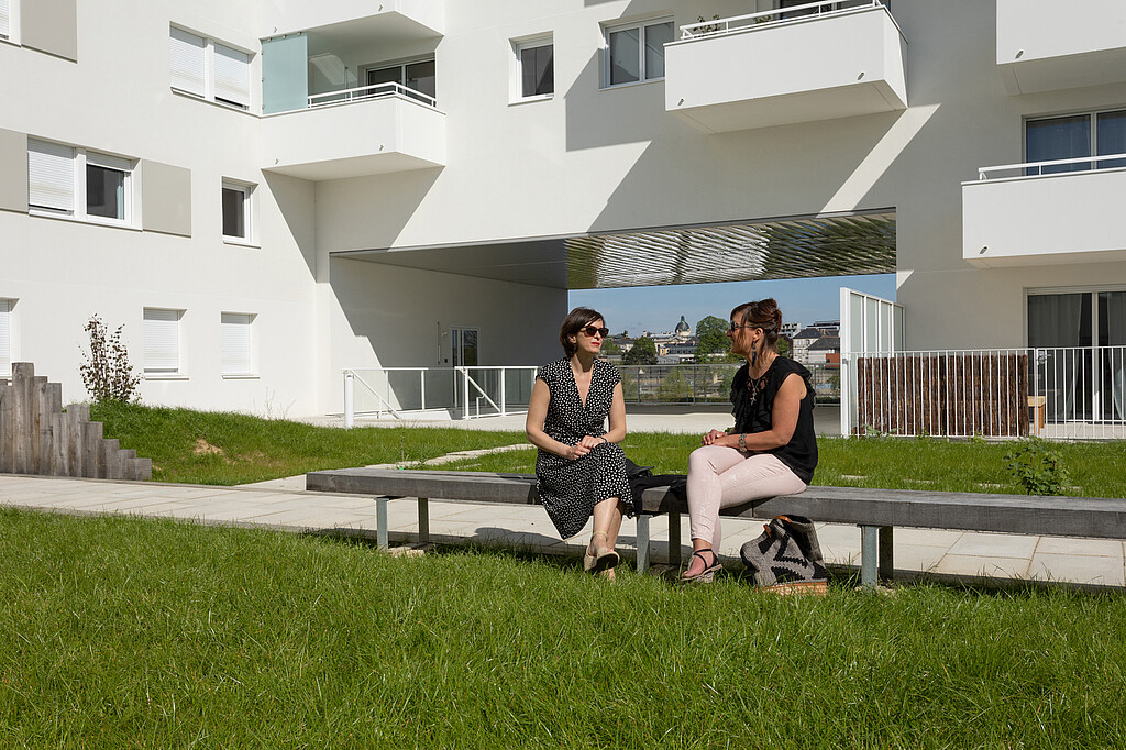Deux jeunes femmes discutent dans le patio du programme Premium