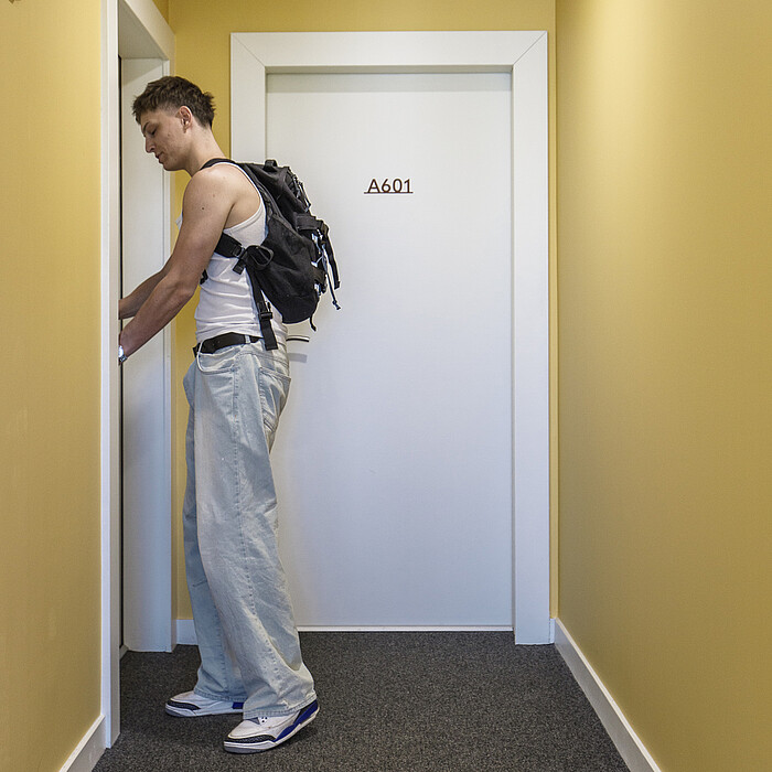Jeune actif ouvrant la porte de son logement
