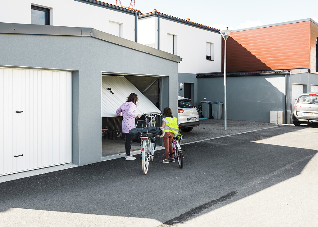 Une maman et sa petite fille entrent dans leur garage