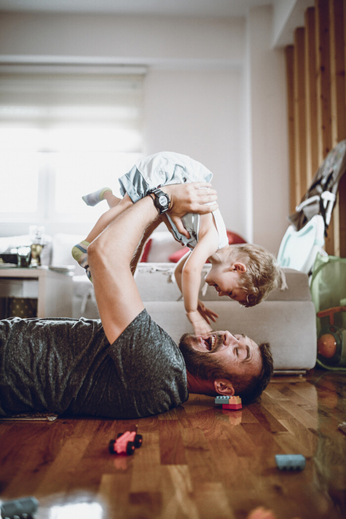 Un papa et son bébé jouent dans leur salon