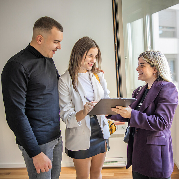 Couple échangeant avec une conseillère pour un projet de location de logement