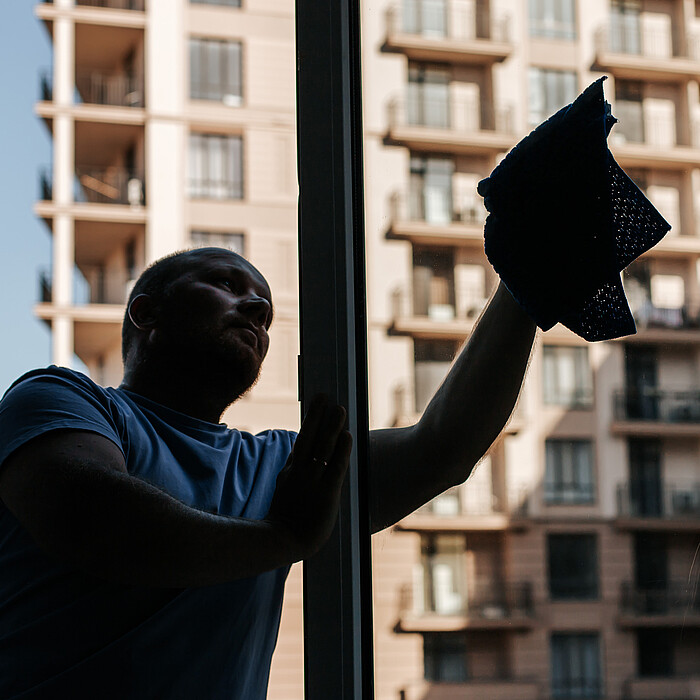 Locataire nettoyant une fenêtre de son logement