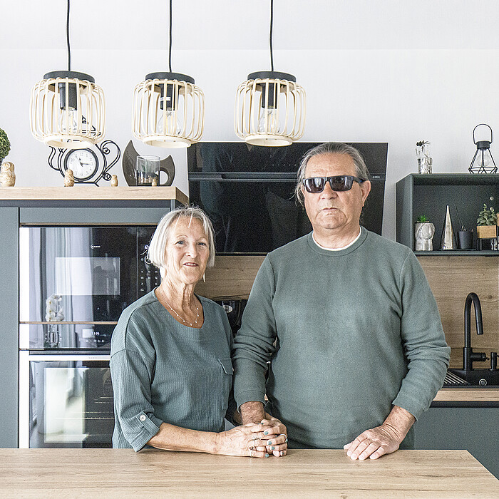 Un couple de séniors posent dans leur cuisine