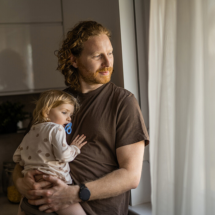 Un père et sa fille regardent par la fenêtre